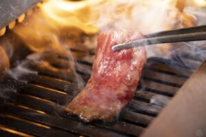 八王子にある一人焼肉大歓迎の焼肉店『焼肉カルロス』で肉を焼いているイメージ画像